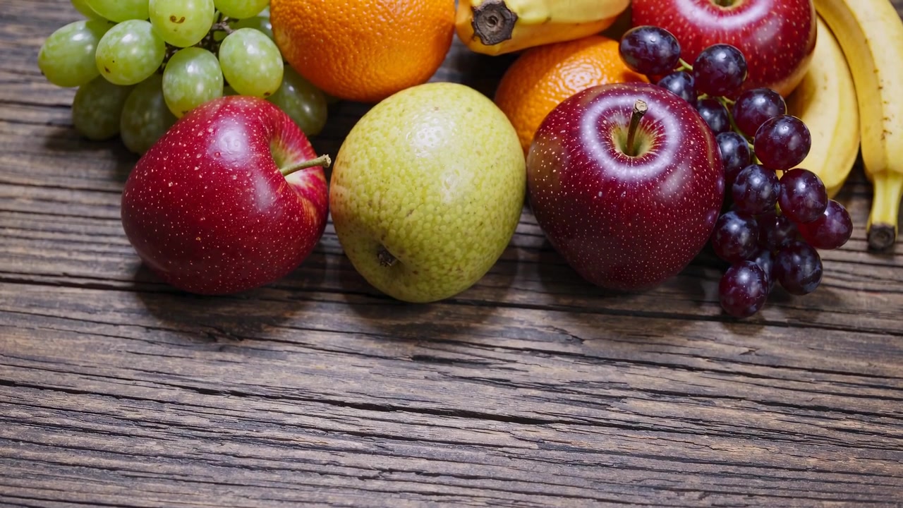 Assorterte friske frukter arrangert på et rustikt trebord