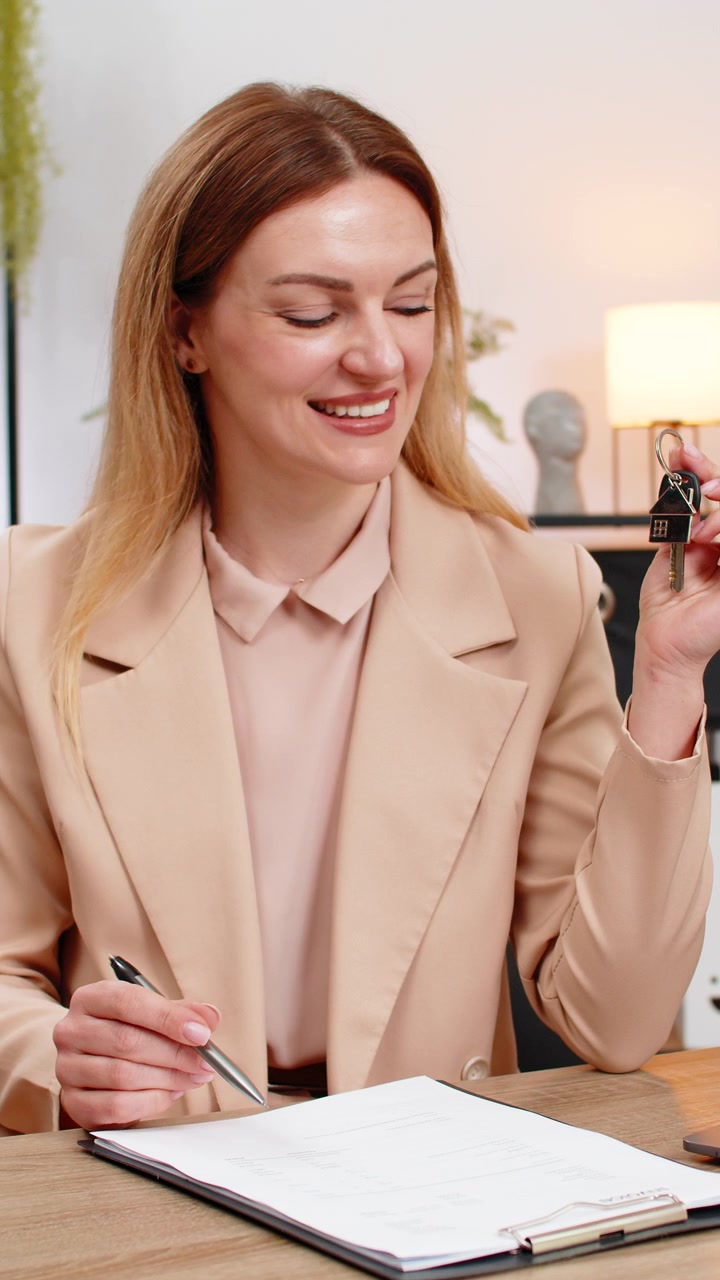 Businesswoman holds keys for new room signs contract paper smiles shows keychain starts new chapter