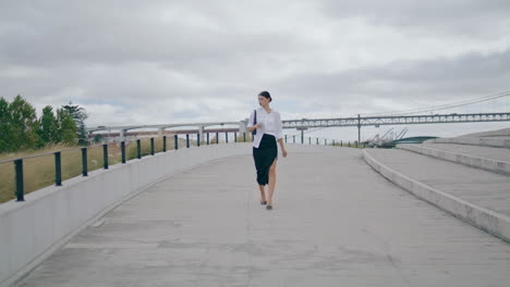 Elegant-model-walking-road-in-front-cloudy-sky.-Business-woman-hurrying-work.