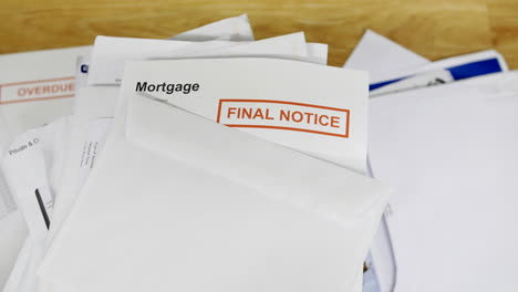 a stack of bills and debts with a mortgage final notice letter