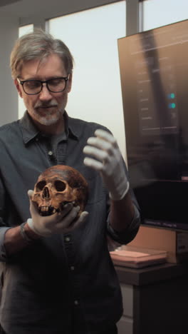 experto examinando un cráneo humano en un museo o laboratorio