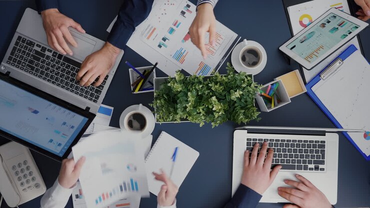 Vista dall'alto del lavoro di squadra aziendale seduto al tavolo della scrivania che pianifica gli investimenti di gestione