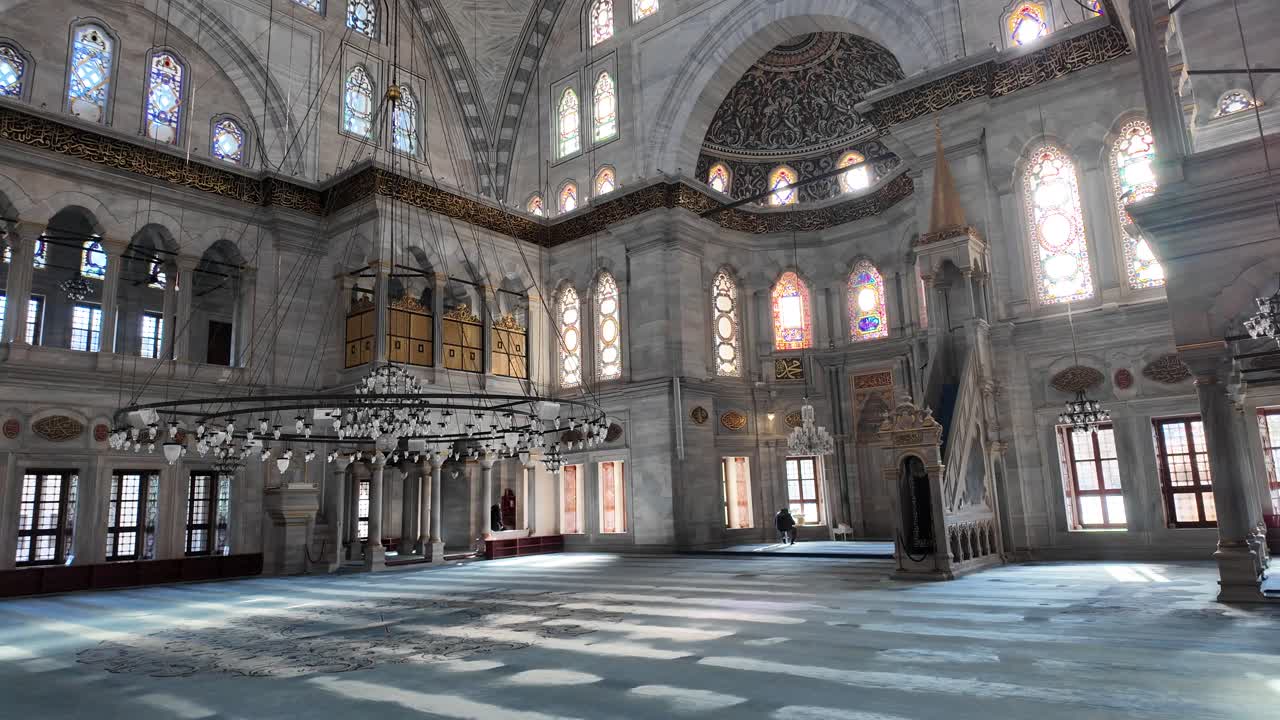 Grande interno di una moschea storica con dettagli ornamentali e vetrate colorate