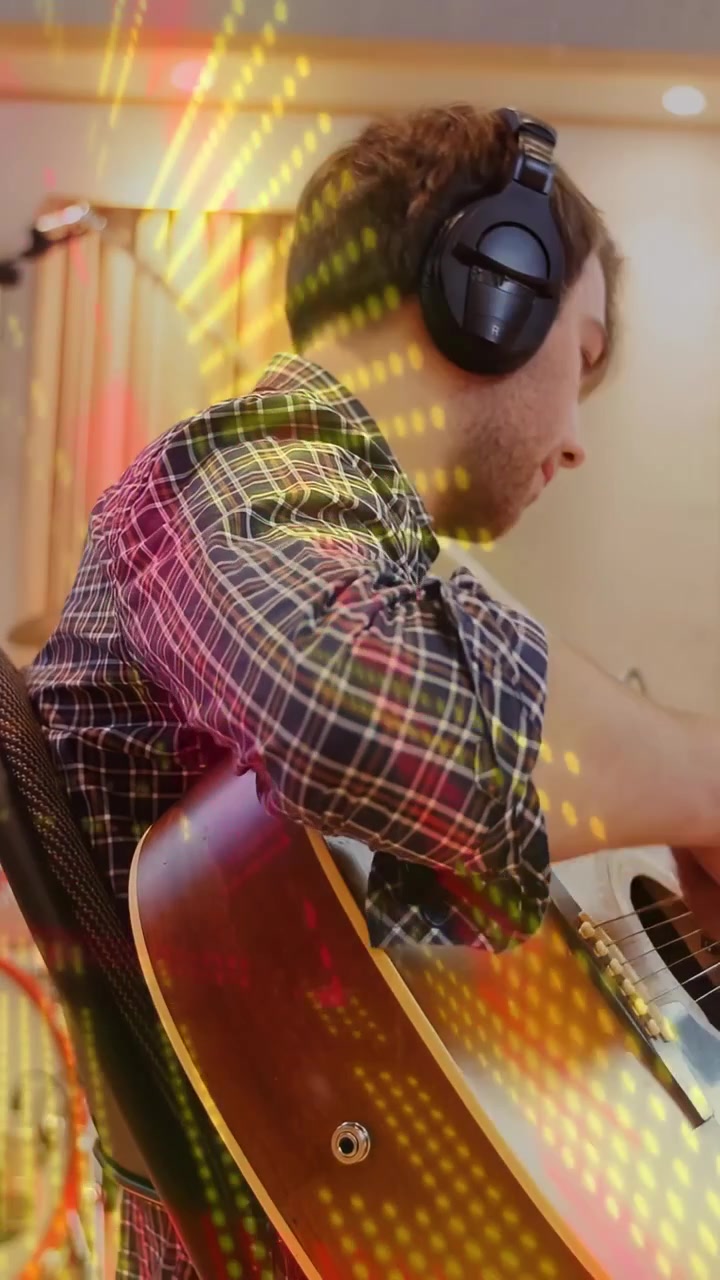 Video verticale: Chitarrista che inizia a strimpellare la chitarra per una registrazione mentre luci calde e puntinate aumentano.