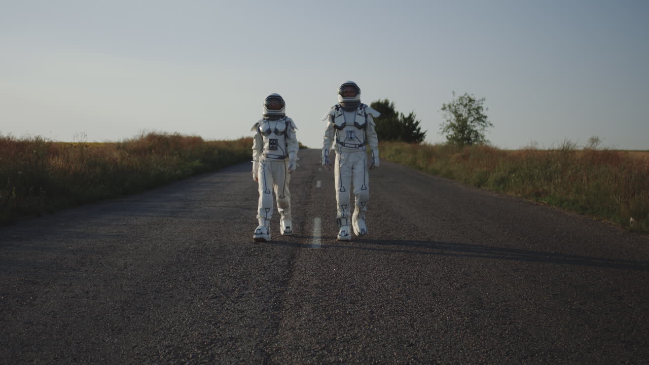 niños en trajes de astronauta caminando por un camino de campo