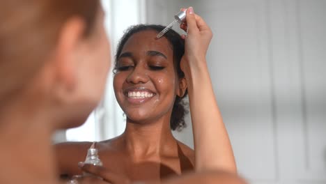 woman applying serum to her face