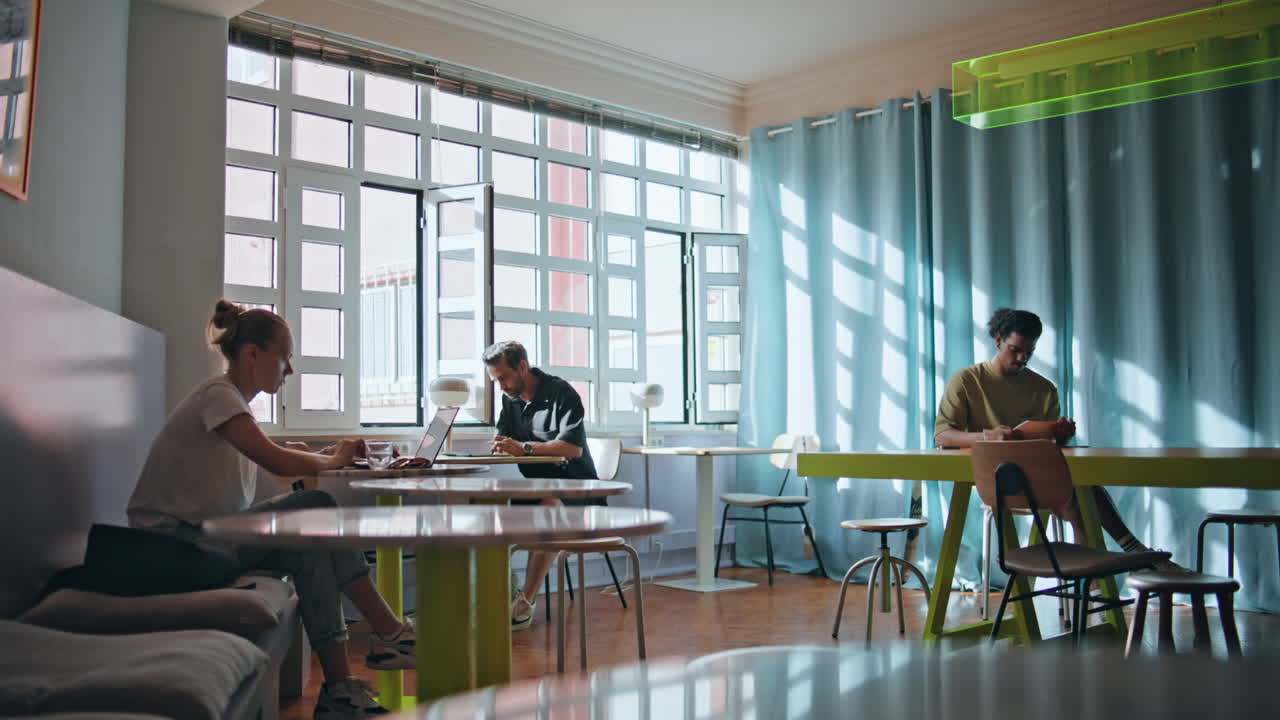 부드러운 빛 아래 카페테리아에 앉아있는 다양한 사람들이. 아한 커피 하우스 인테리어