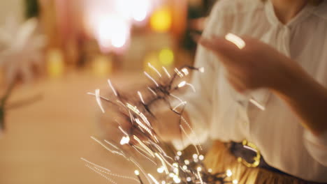 woman untangling christmas lights in warm interior