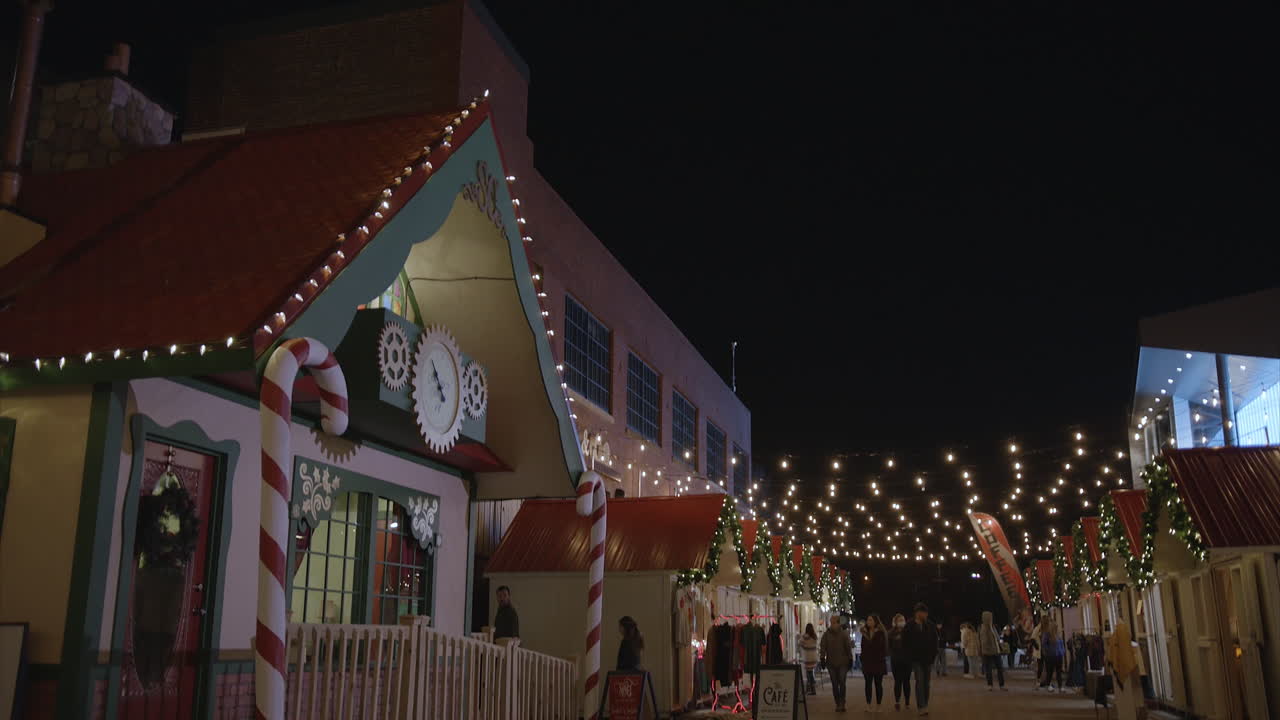 Tilt down view of tourists visiting a pop-up Christmas village to do some shopping.