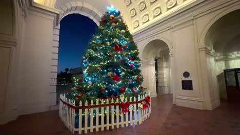 entrada del ayuntamiento de pasadena con un árbol de navidad iluminado bellamente decorado, toma nocturna inclinada hacia arriba