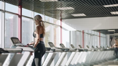 Young-woman-training-on-treadmill-in-fitness-club.-Pretty-woman-training-cardio