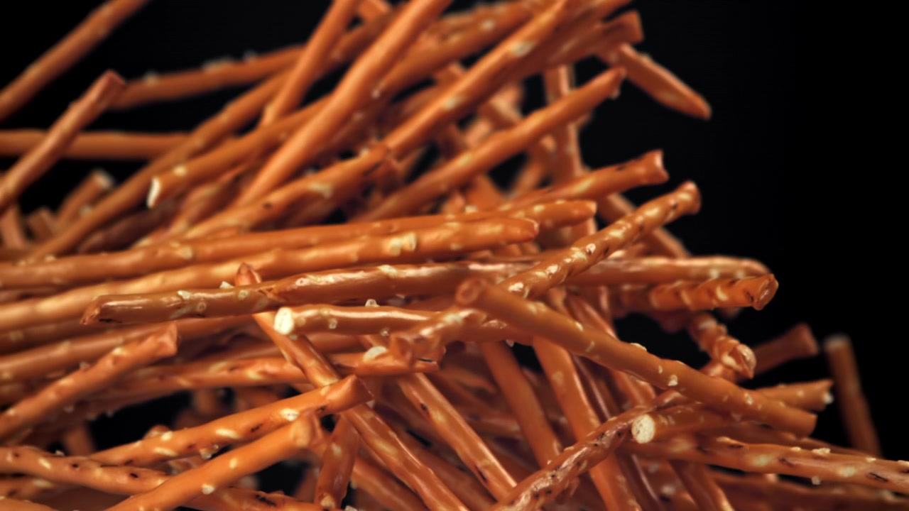 Bastoncini di pretzel salati che cadono e risalgono al rallentatore.