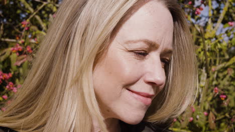 portrait of a blonde woman smiling outdoors