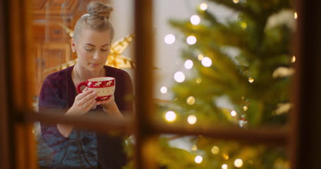 Woman-Drinking-Coffee-At-Home-Seen-Through-Window-1