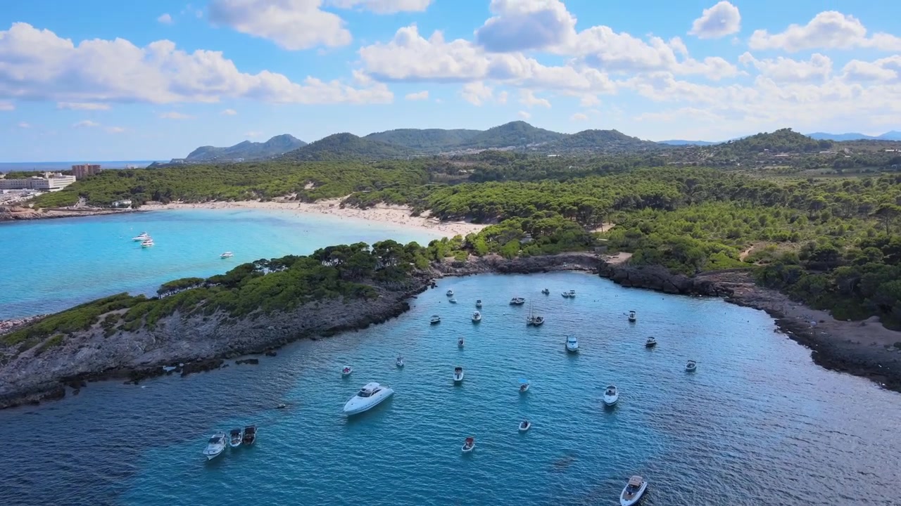 Esplora la splendida Cala Agulla a Cala Rajada, Maiorca. Goditi le serene acque turchesi e l'ambiente rilassante, perfetto per gite in barca e per rilassarsi sotto il sole.