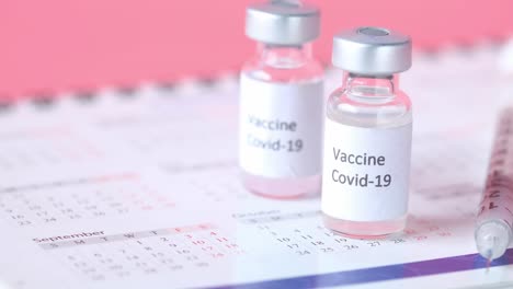 covid-19 vaccine vials and calendar