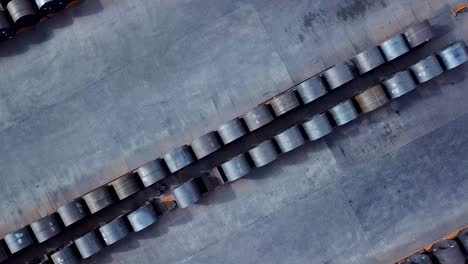Symmetrical-rows-of-manufactured-steel-rolls-stored-outside-aerial-top-down-view