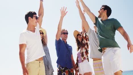 friends forming hand stack at beach