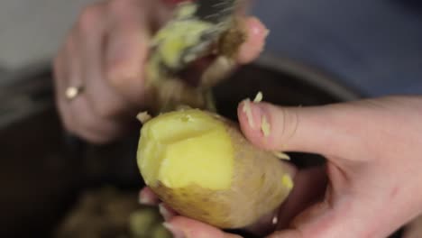 mujer pelando patatas hervidas. primer plano de las manos