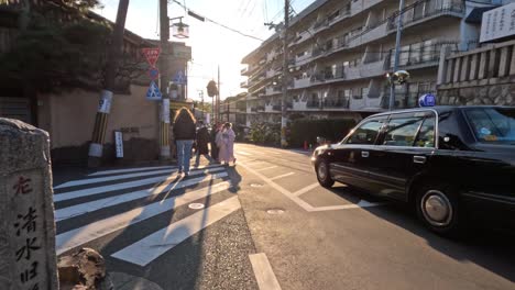 people crossing the street as a car waits