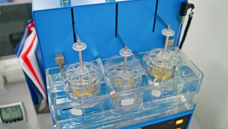 experiments at the lab. sliding shot of a dissolution apparatus testing medication pills dissolving tablets in liquid. laboratory routine.