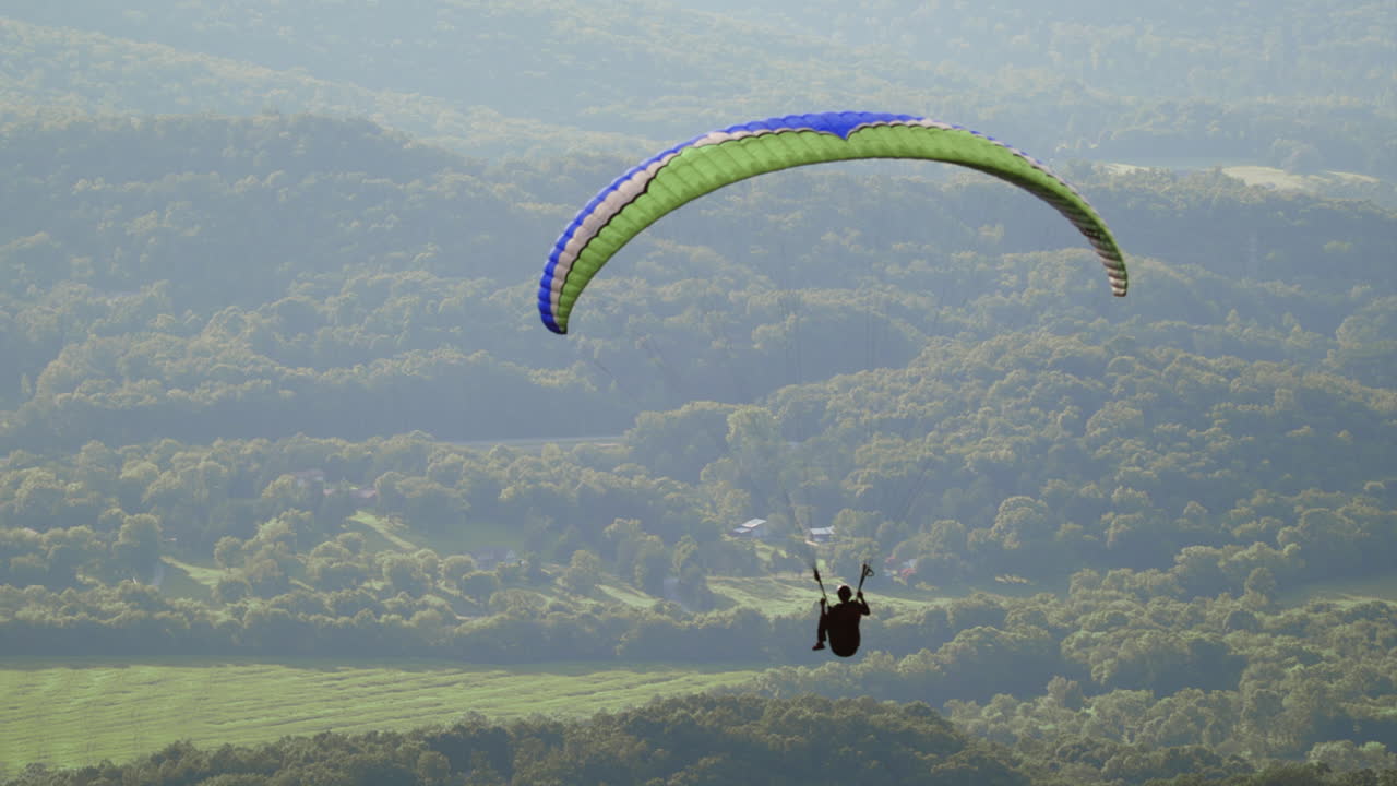 parapente volando por el aire, solo parapente flota pacíficamente en cámara lenta
