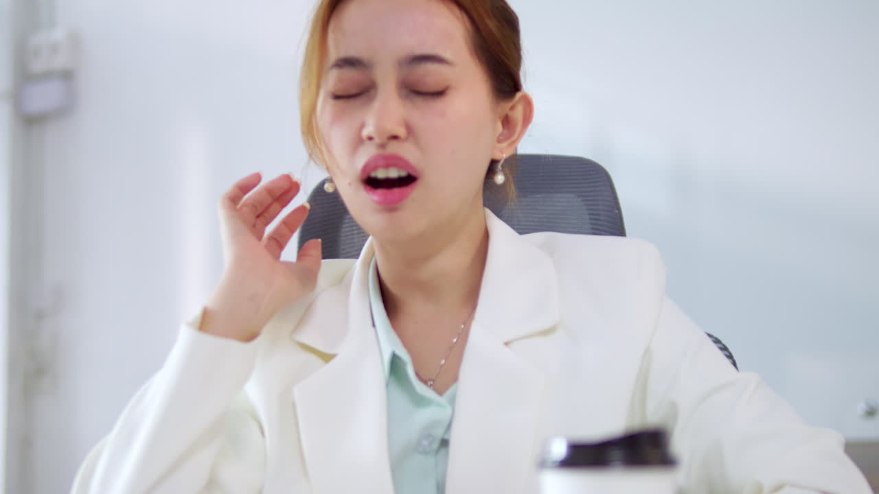 An employee is massaging her neck to relieve herself of her office syndrome that causes pain to her neck and upper back.