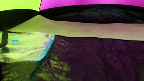 green and violet tent in a coniferous forest, camping land. summer, hike, backpacking. tent near the sea. panning forward into the tent and hand open the door of the tent