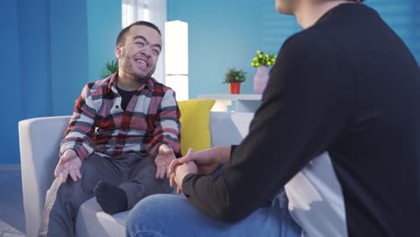 a young man with dwarfism is chatting with his friend at home and they have a happy and sincere conversation.
