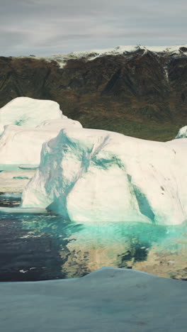 massive iceberg floating in the ocean, with a mountain in the background.