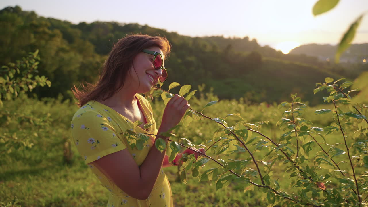 mujer disfrutando de la puesta de sol en un jardín