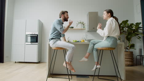 pareja amorosa charlando y almorzando juntos sentados en un taburete en una cocina moderna 1