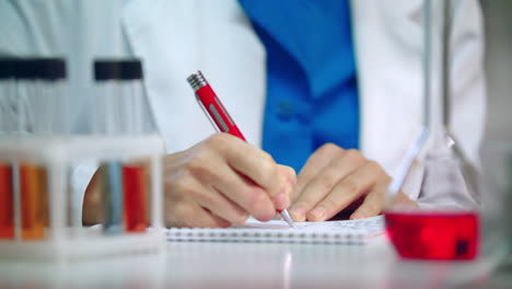 investigador de laboratorio escribiendo un informe de investigación. estudiante de medicina escribiendo datos clínicos