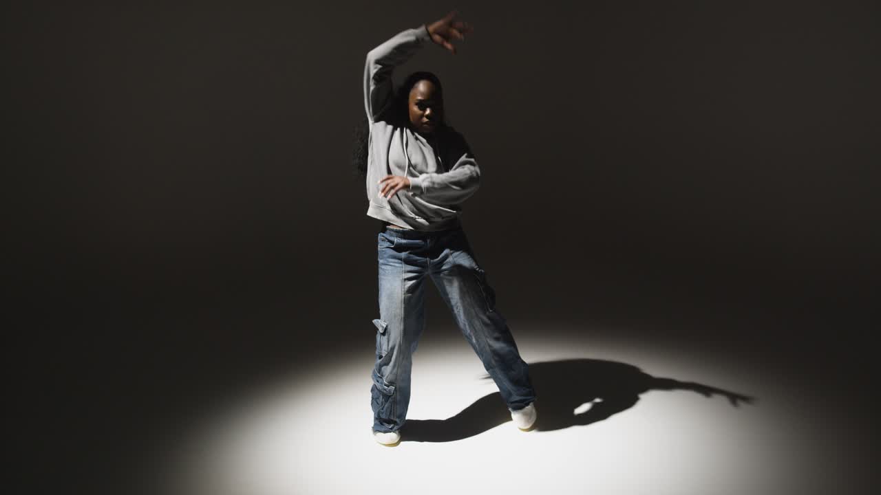 Full Length Studio Portrait Shot Of Young Woman Dancing In Spotlight