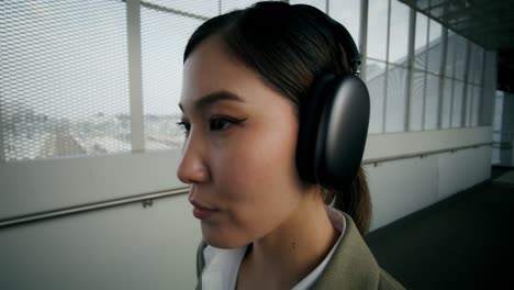 woman wearing headphones on a city overpass