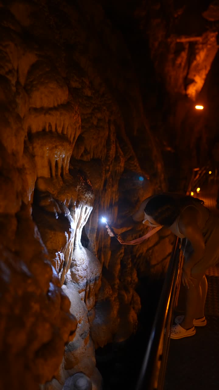 Woman exploring a cave with a flashlight