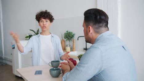 una pareja discutiendo en la cocina.