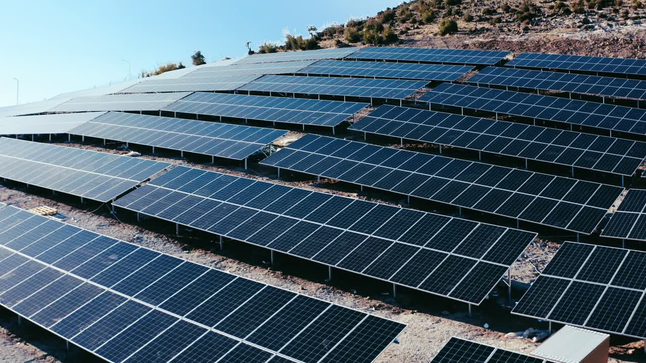 Ripresa con drone di file di pannelli solari in un impianto fotovoltaico.