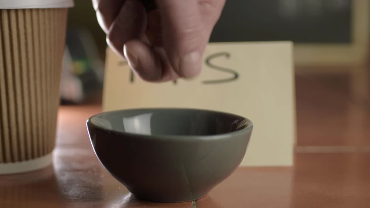 manos poniendo monedas en un frasco de puntas primer plano