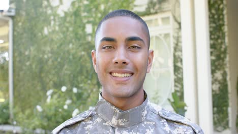 retrato de un feliz soldado masculino biracial en el jardín