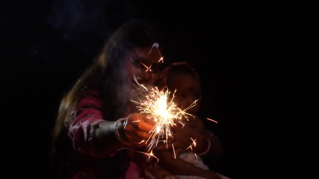 A mother and her child burning crackers on Diwali