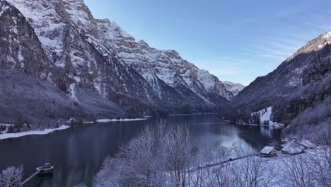 Breathtaking aerial view of Lake Klöntalersee on a winter day, showcasing its serene beauty and surrounding snowy landscape.