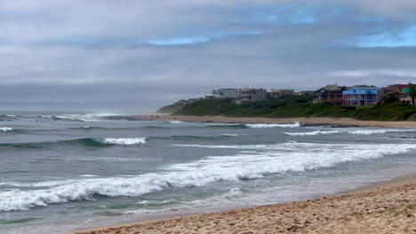 Surfers-surf-swell-JBAY-Jefferys-Bay-South-Africa-wave-Supers-Impossibles-Boneyard-WSL-Corona-Open-waves-crashing-on-beach-daytime-summer-beautiful-partly-cloudy-slow-motion-pan-to-the-left