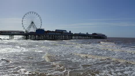 Stunning-aerial-view-of-the-famous-Blackpool-pier-at-high-tide,-by-the-award-winning-Blackpool-beach,-A-very-popular-seaside-tourist-location-in-England-,-United-Kingdom,-UK