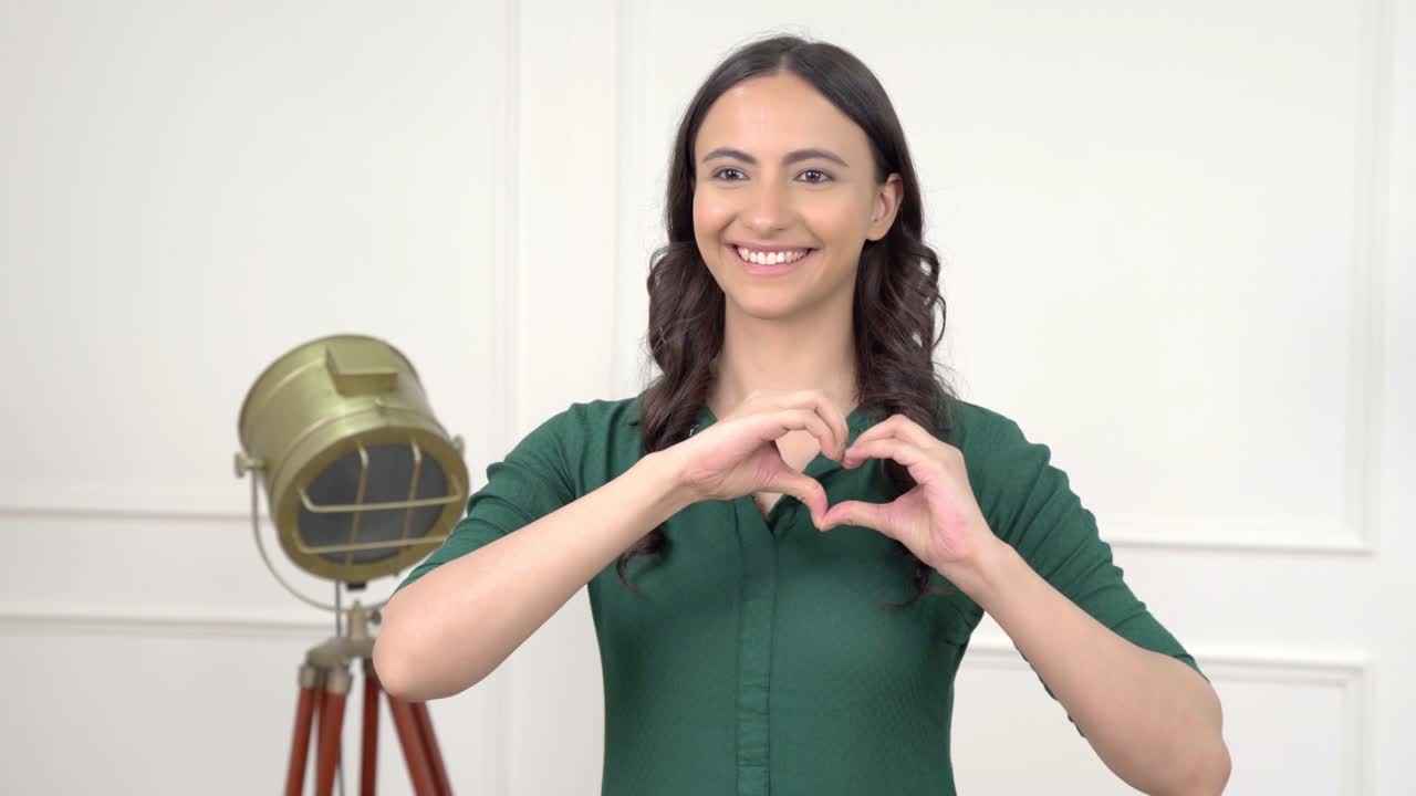 chica india mostrando el signo del corazón