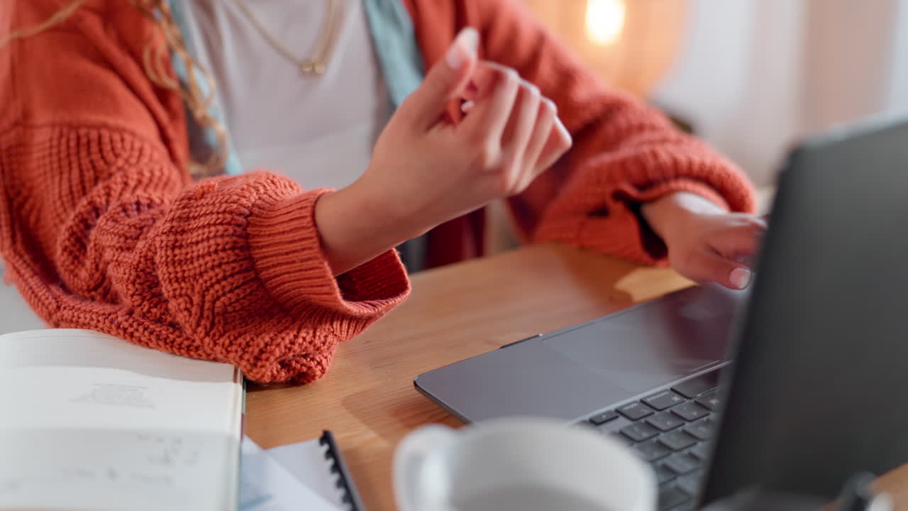 Woman experiencing wrist pain while working on a laptop