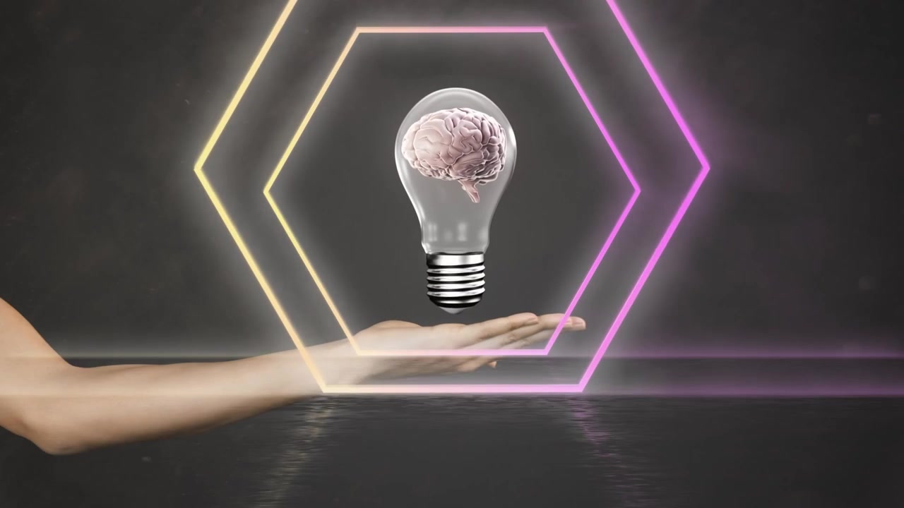 Animazione di esagoni al neon su una lampadina con un cervello, sopra le mani di una donna caucasica su sfondo nero.