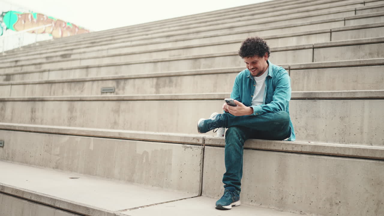 Man sitting on stairs using his phone