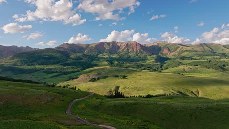 aerial over green hills near the crested butte mountain, colorado, usa