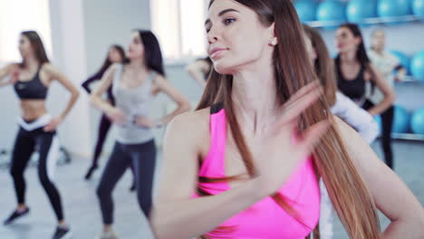 beautiful sporty young women are working in gym on the background of fitness balls. a group of sports people exercise in fitness center. athletic girls in sportswear indoors.